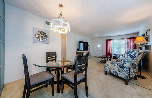 carpeted dining room with a textured ceiling and a chandelier