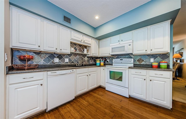 kitchen featuring white cabinets, dark hardwood / wood-style floors, white appliances, and sink