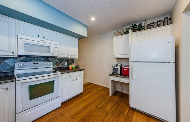 kitchen featuring decorative backsplash, wood-type flooring, white appliances, and white cabinets