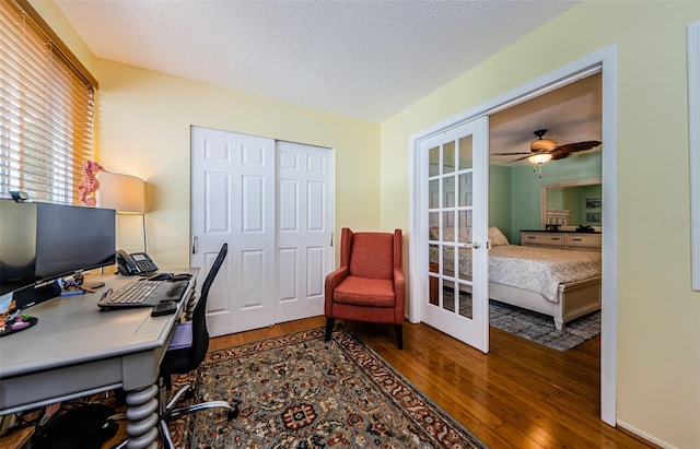 office area featuring a textured ceiling, wood-type flooring, ceiling fan, and french doors