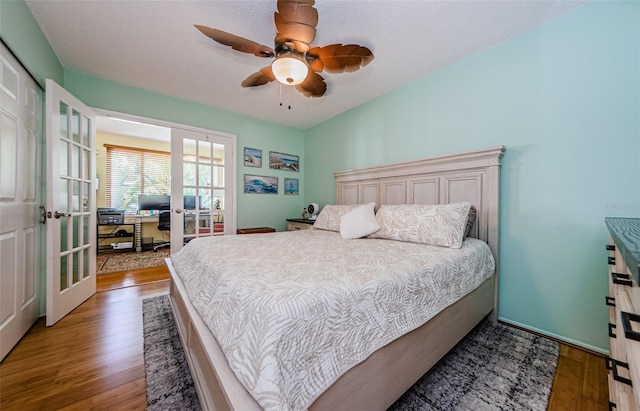 bedroom with a textured ceiling, french doors, light wood-type flooring, and ceiling fan