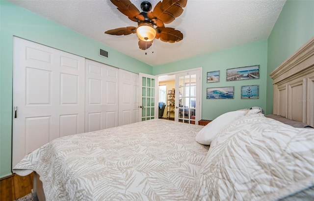 bedroom with a closet, ceiling fan, hardwood / wood-style floors, french doors, and a textured ceiling