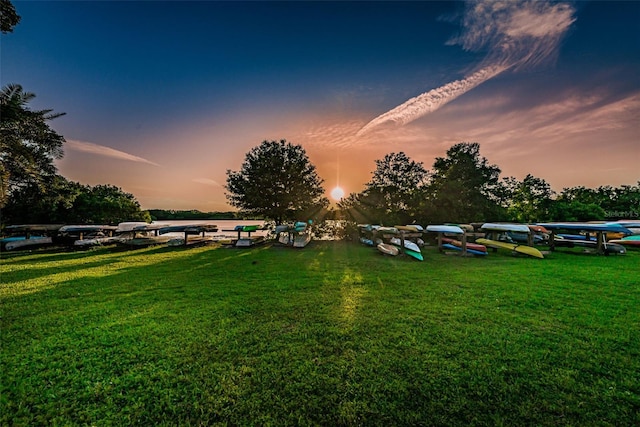 yard at dusk featuring a water view