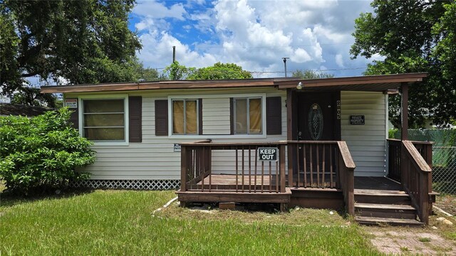 view of front facade featuring a front lawn and a wooden deck