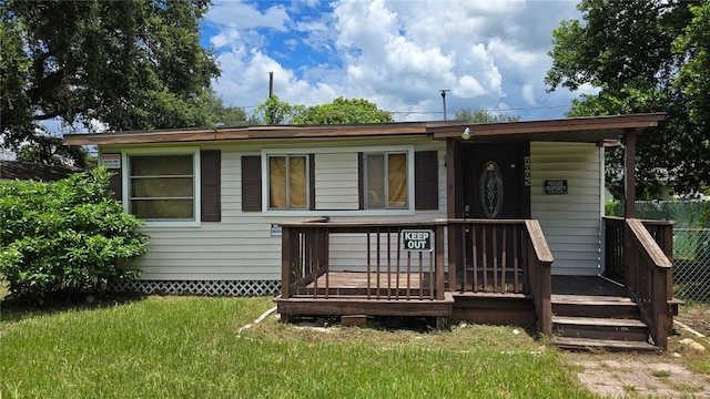 rear view of property with a lawn and a deck