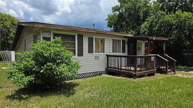 view of front facade featuring a deck and a front yard