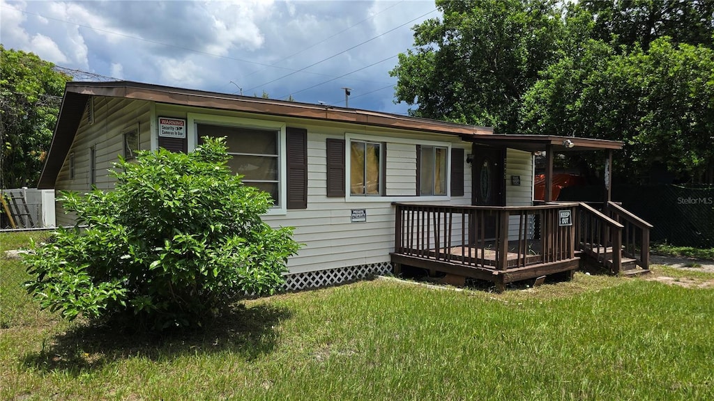 view of front of home featuring a front lawn and a deck