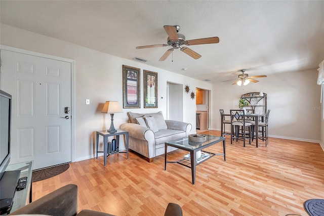 living room featuring ceiling fan and light wood-type flooring