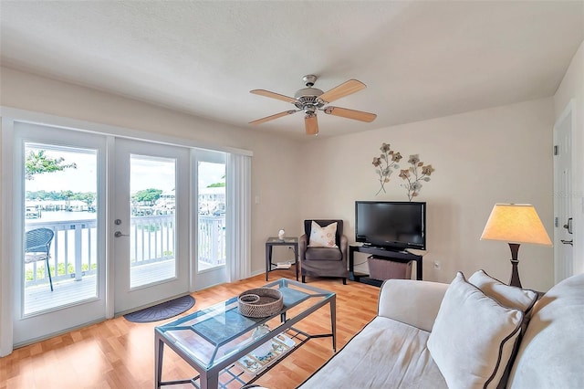 living room with ceiling fan and light hardwood / wood-style floors