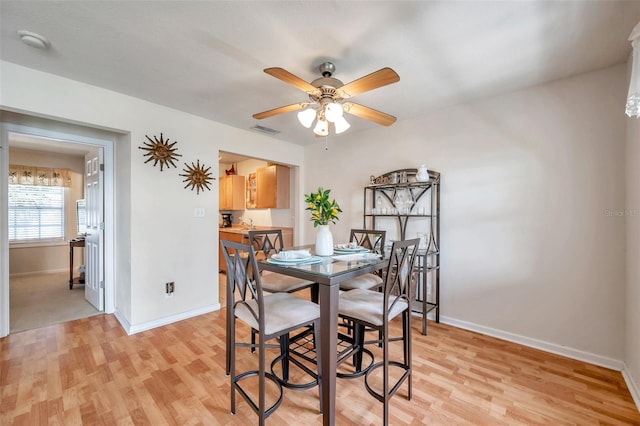 dining room with ceiling fan and light hardwood / wood-style flooring