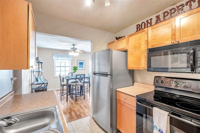 kitchen with sink, light tile patterned floors, ceiling fan, and black appliances