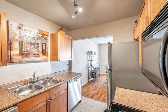 kitchen featuring light tile patterned flooring, stainless steel dishwasher, rail lighting, and sink