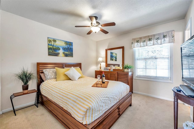 bedroom featuring ceiling fan, light colored carpet, and a textured ceiling