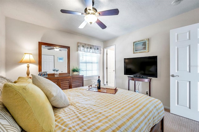 carpeted bedroom with a textured ceiling and ceiling fan