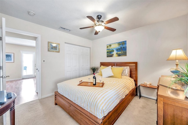 bedroom with light carpet, ceiling fan, and a closet