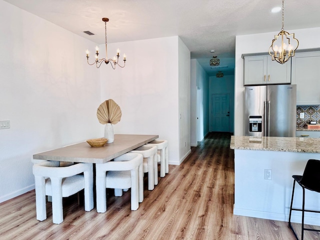 dining space featuring hardwood / wood-style flooring and a notable chandelier