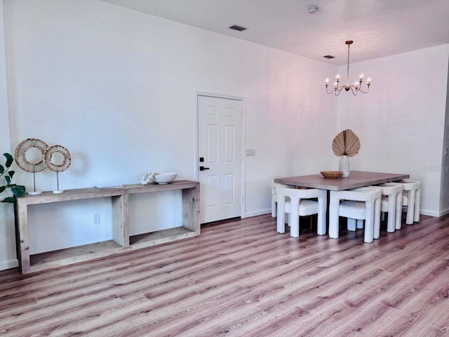 dining area with a chandelier and light hardwood / wood-style floors