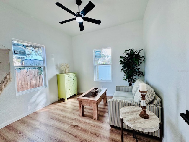 living area featuring light wood-type flooring and ceiling fan