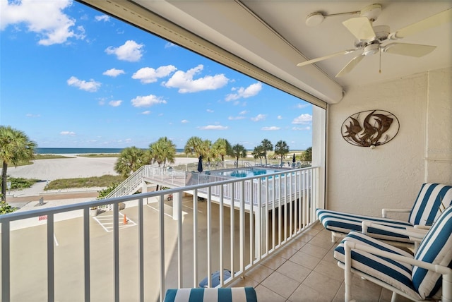 balcony with ceiling fan and a water view