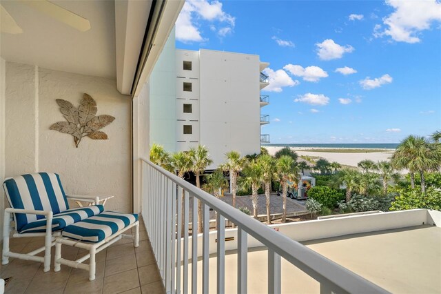 balcony featuring a water view and a beach view