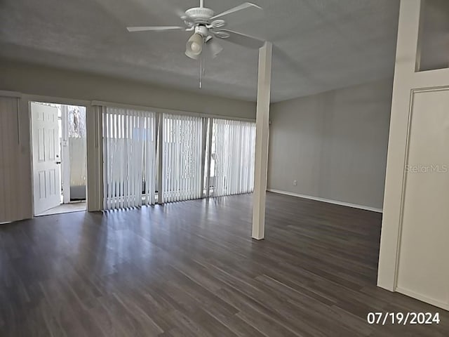 empty room featuring dark wood-type flooring and ceiling fan