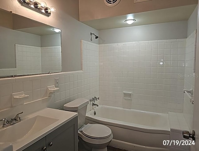 535 Monterey Blvd NE, Saint Petersburg, FL 33704 - full bathroom featuring vanity, tiled shower / bath combo, tile walls, and toilet