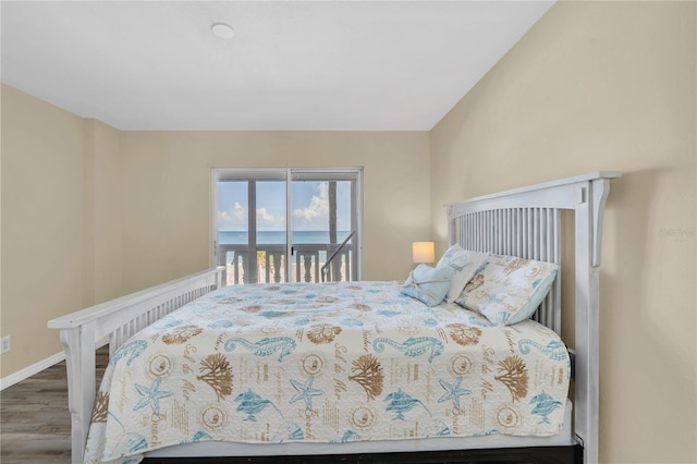 bedroom with a water view, access to exterior, and hardwood / wood-style flooring