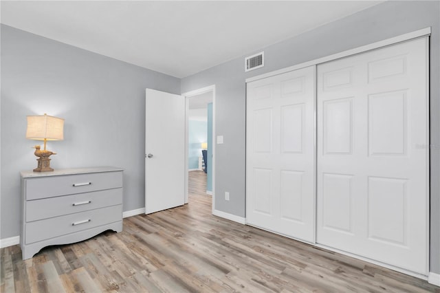 unfurnished bedroom with a closet and light wood-type flooring