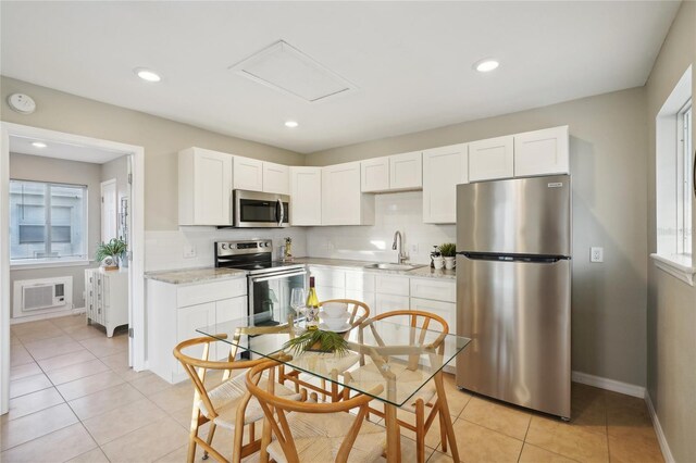 kitchen featuring white cabinetry, sink, stainless steel appliances, and light stone countertops