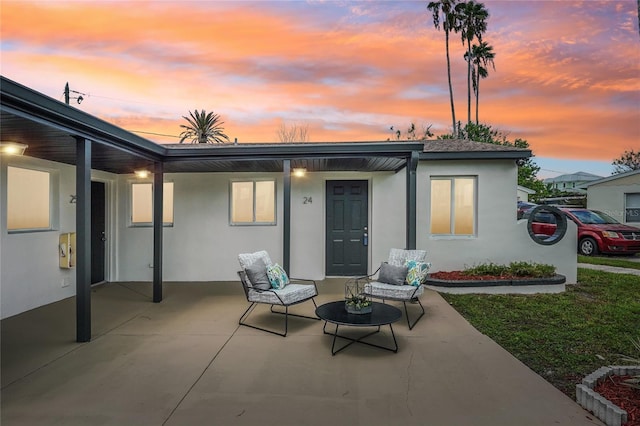 back house at dusk with a patio