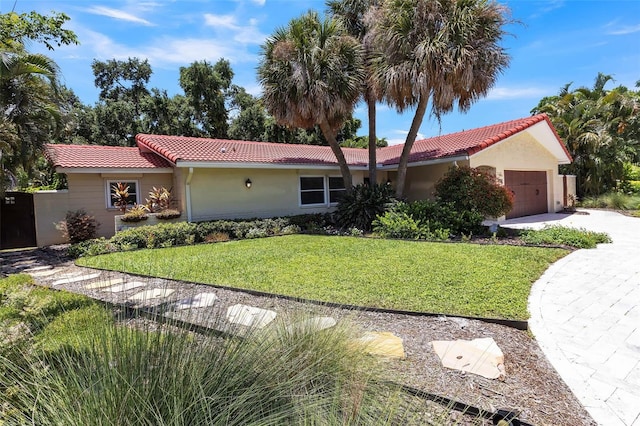 view of front of house with a garage and a front lawn