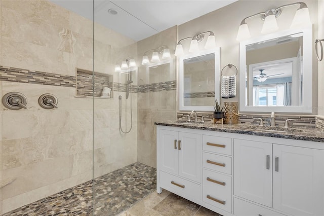 bathroom with ceiling fan, tiled shower, and vanity