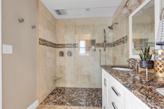 bathroom with vanity and a tile shower