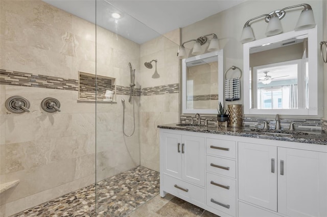 bathroom with a tile shower and vanity