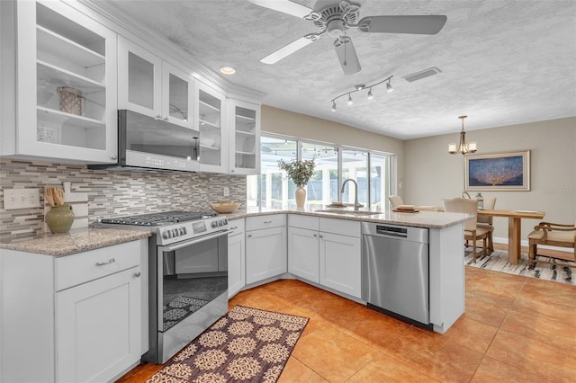 kitchen featuring decorative light fixtures, sink, white cabinets, and stainless steel appliances