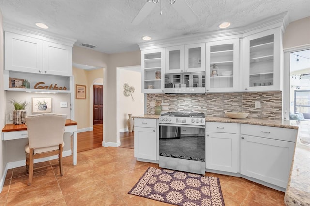 kitchen featuring light stone counters, white cabinetry, and stainless steel gas range