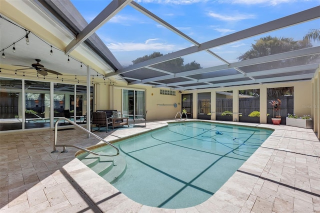 view of pool with glass enclosure and a patio area