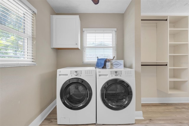 laundry area featuring light wood-type flooring, cabinets, and washer and dryer