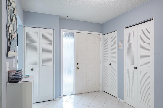 interior space with light tile patterned floors and a textured ceiling