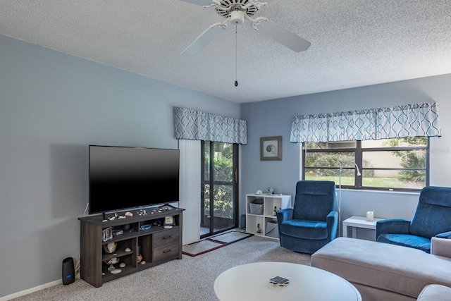 living room featuring carpet, ceiling fan, and a textured ceiling