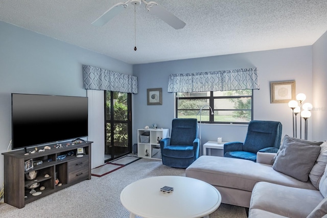 living room featuring a textured ceiling, carpet, and ceiling fan