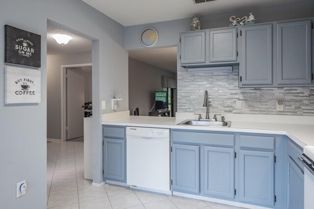 kitchen featuring range, tasteful backsplash, sink, light tile patterned flooring, and dishwasher