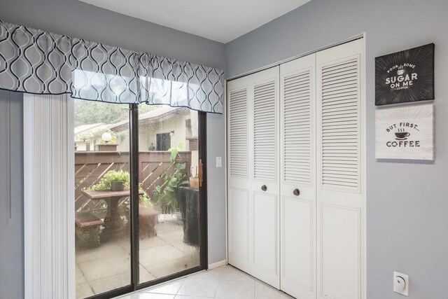 doorway with a wealth of natural light and light tile patterned floors