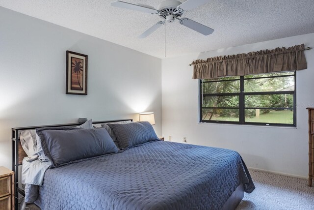 bedroom with carpet floors, a textured ceiling, and ceiling fan