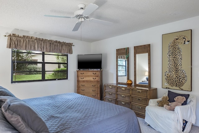 carpeted bedroom featuring a textured ceiling and ceiling fan