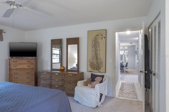 bedroom with a closet, carpet, a textured ceiling, and ceiling fan