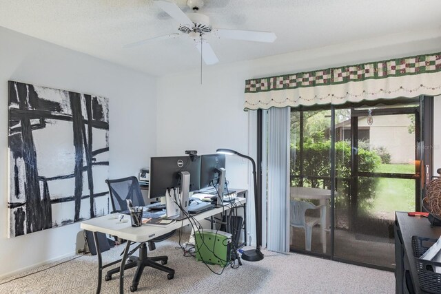 home office featuring carpet, ceiling fan, and a textured ceiling