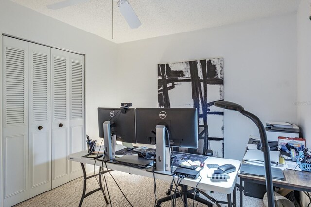 carpeted office featuring a textured ceiling and ceiling fan