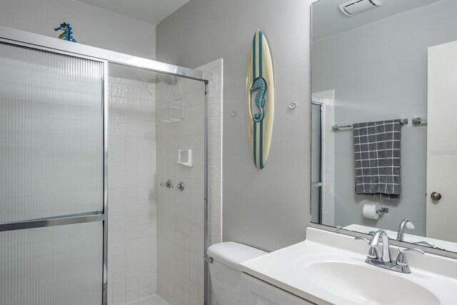 bathroom featuring vanity, walk in shower, and toilet