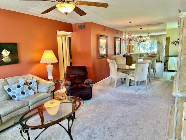 carpeted living room with ceiling fan with notable chandelier